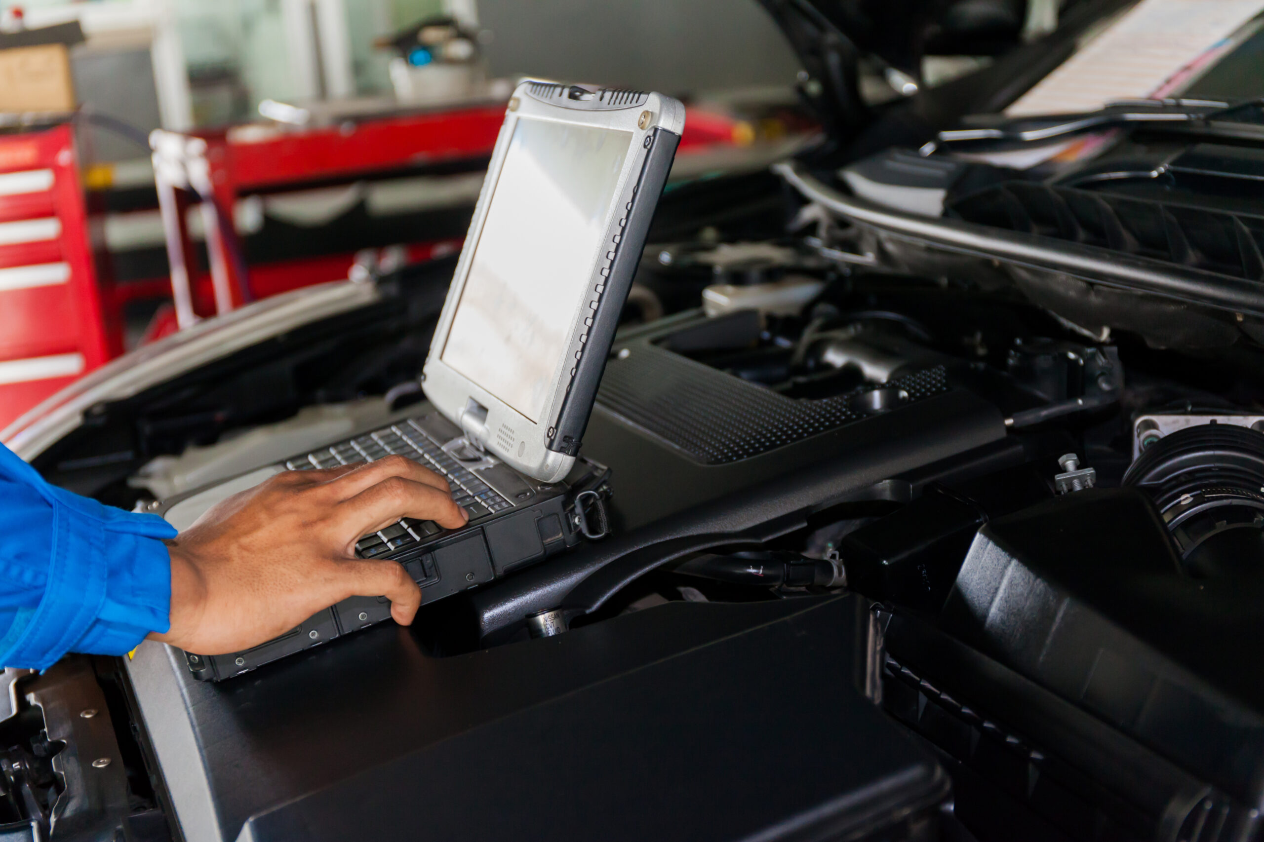 Mechanic using Diagnostic machine tools for car